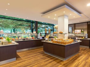 Un buffet de petit-déjeuner moderne proposant une variété d’aliments et un espace dédié aux boissons chaudes.