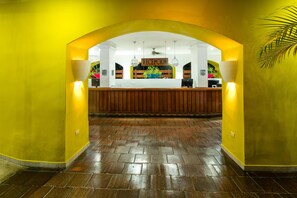 A reception area with a wooden reception desk, a sign reading 'RECEPTION', and a potted plant.