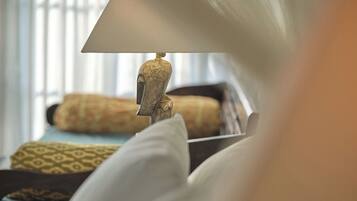 A bed with patterned pillows and a lamp with a decorative base.