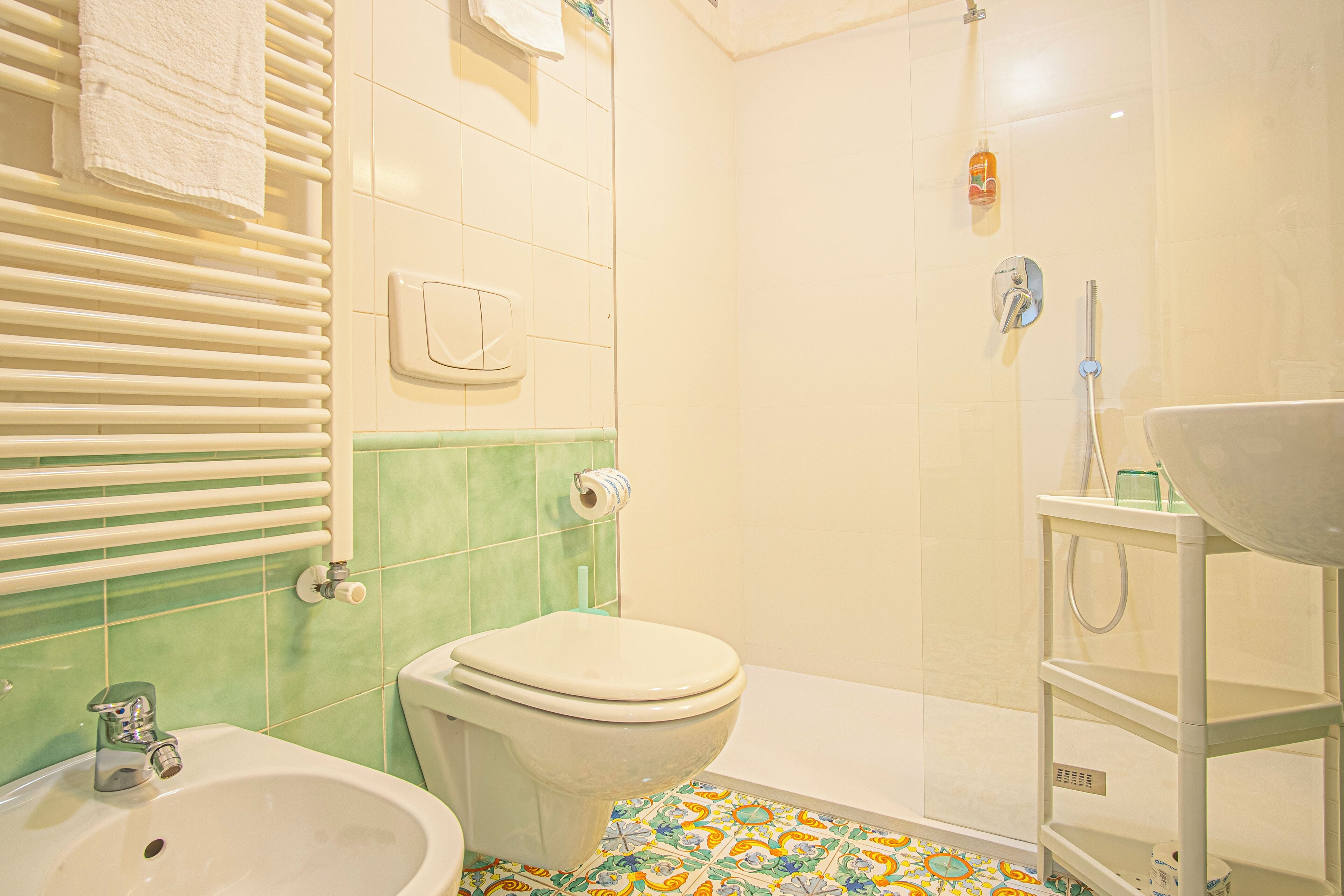 Een badkamer met toilet, wastafel en douche.