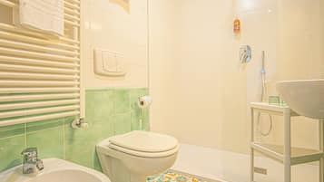 A bathroom with a toilet, sink, and shower.