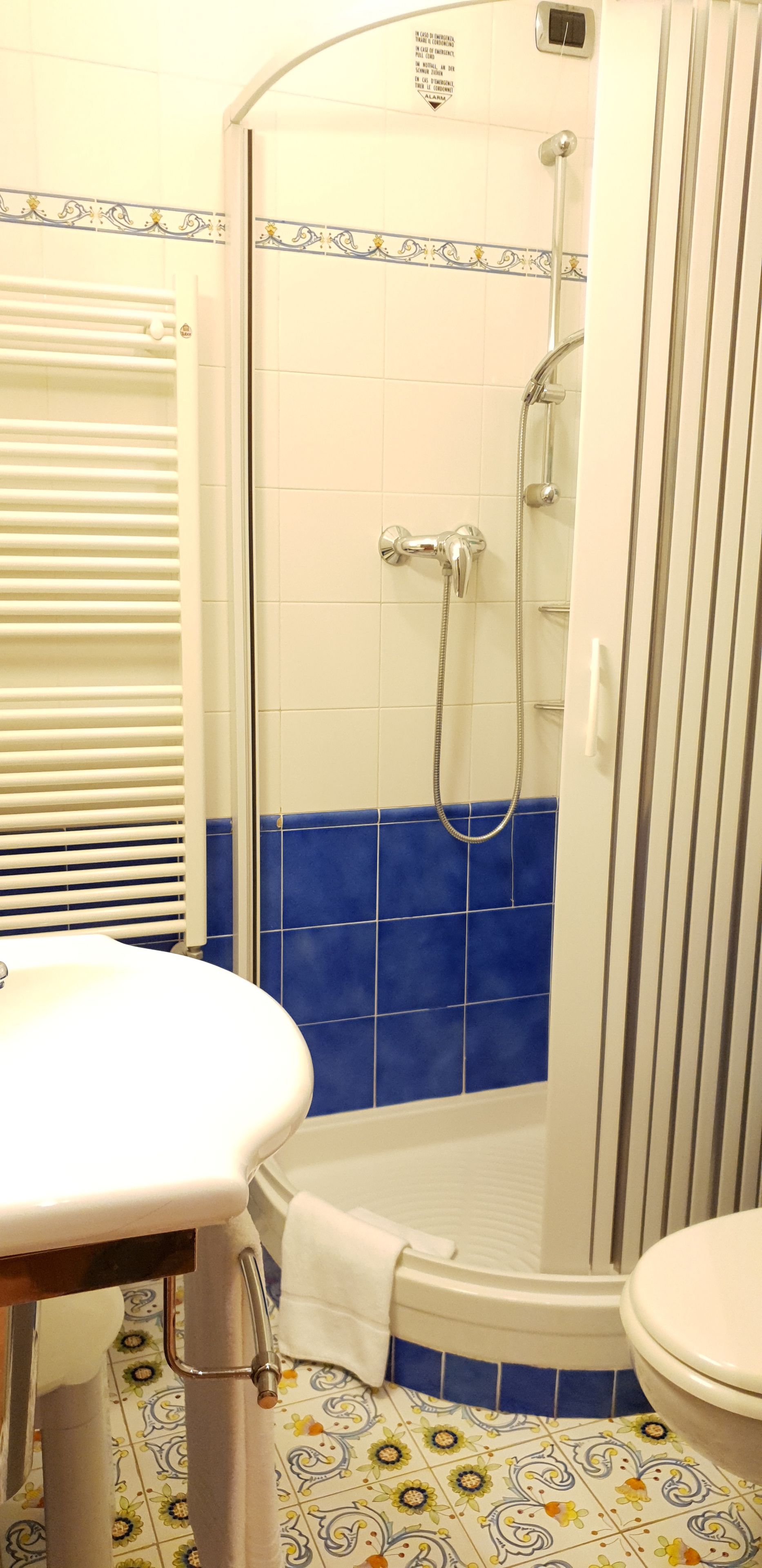 A bathroom with a shower, toilet, and sink.
