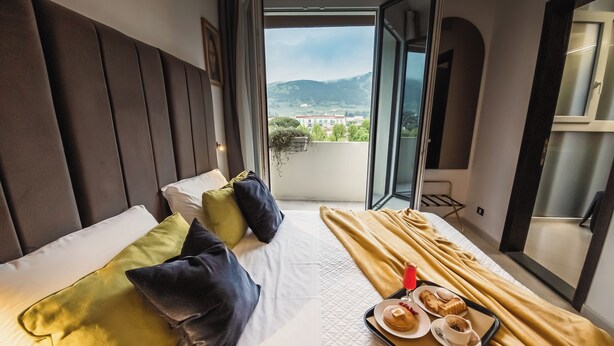 Una habitación de hotel con una cama, una bandeja de desayuno y vistas al exterior.