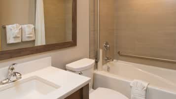 A modern bathroom with a sink, toilet, and bathtub.
