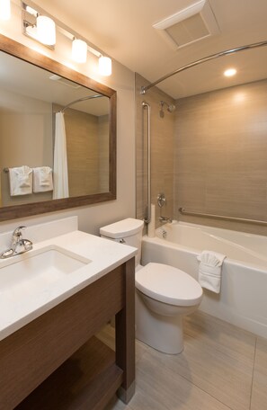 A modern bathroom with a sink, toilet, and bathtub.