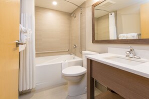 A modern bathroom with a bathtub, toilet, and sink.