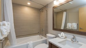 A modern bathroom with a bathtub, toilet, and sink.