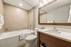 Un baño moderno con bañera, inodoro y tocador.
