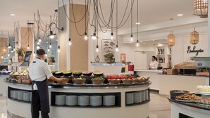 Ein Buffet mit verschiedenen Speisen und einem Mitarbeiter, der bedient.