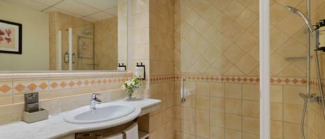 Une salle de bain avec un lavabo, un miroir et une douche.