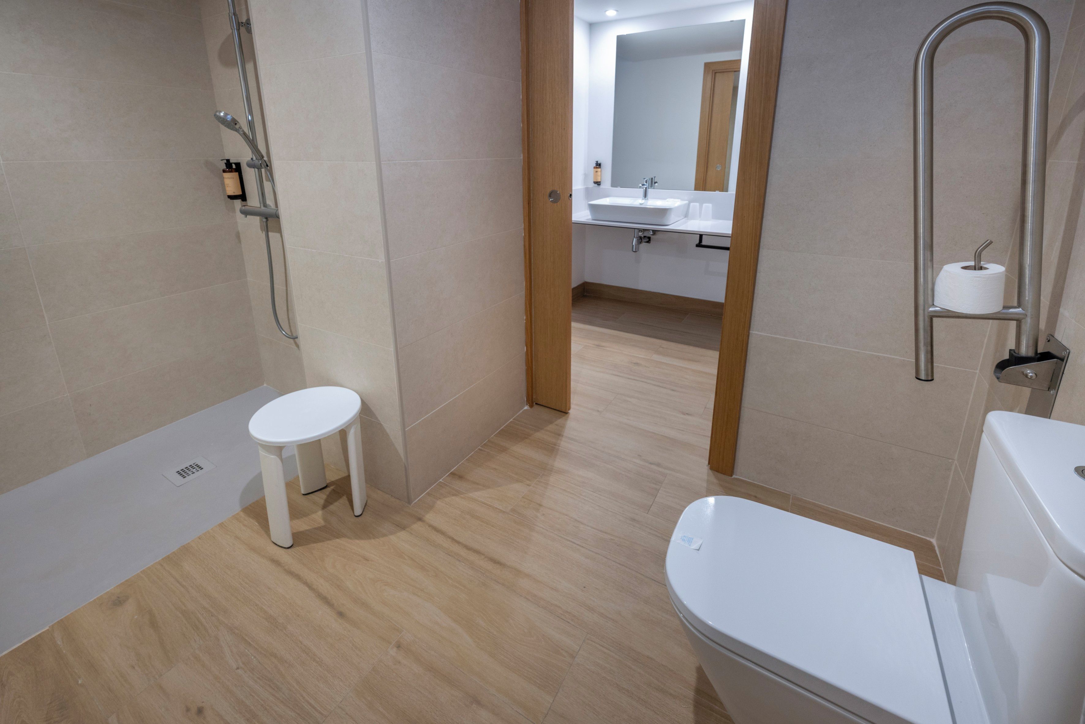 A modern bathroom with a shower, toilet, and sink.