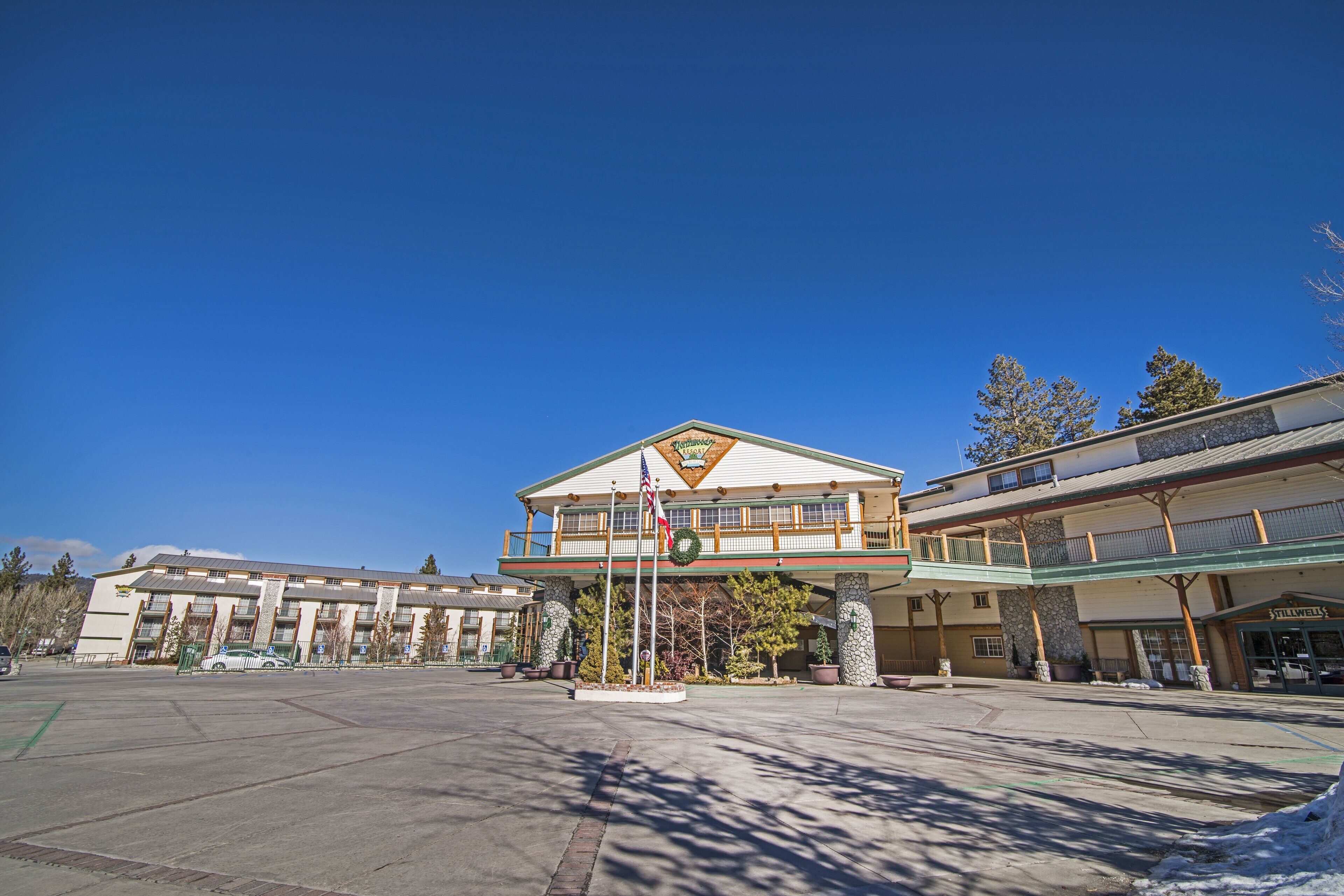 A hotel with a central building and a covered walkway.