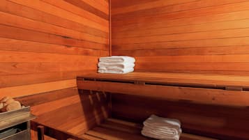 Una sauna de madera con bancos y una pila de toallas.