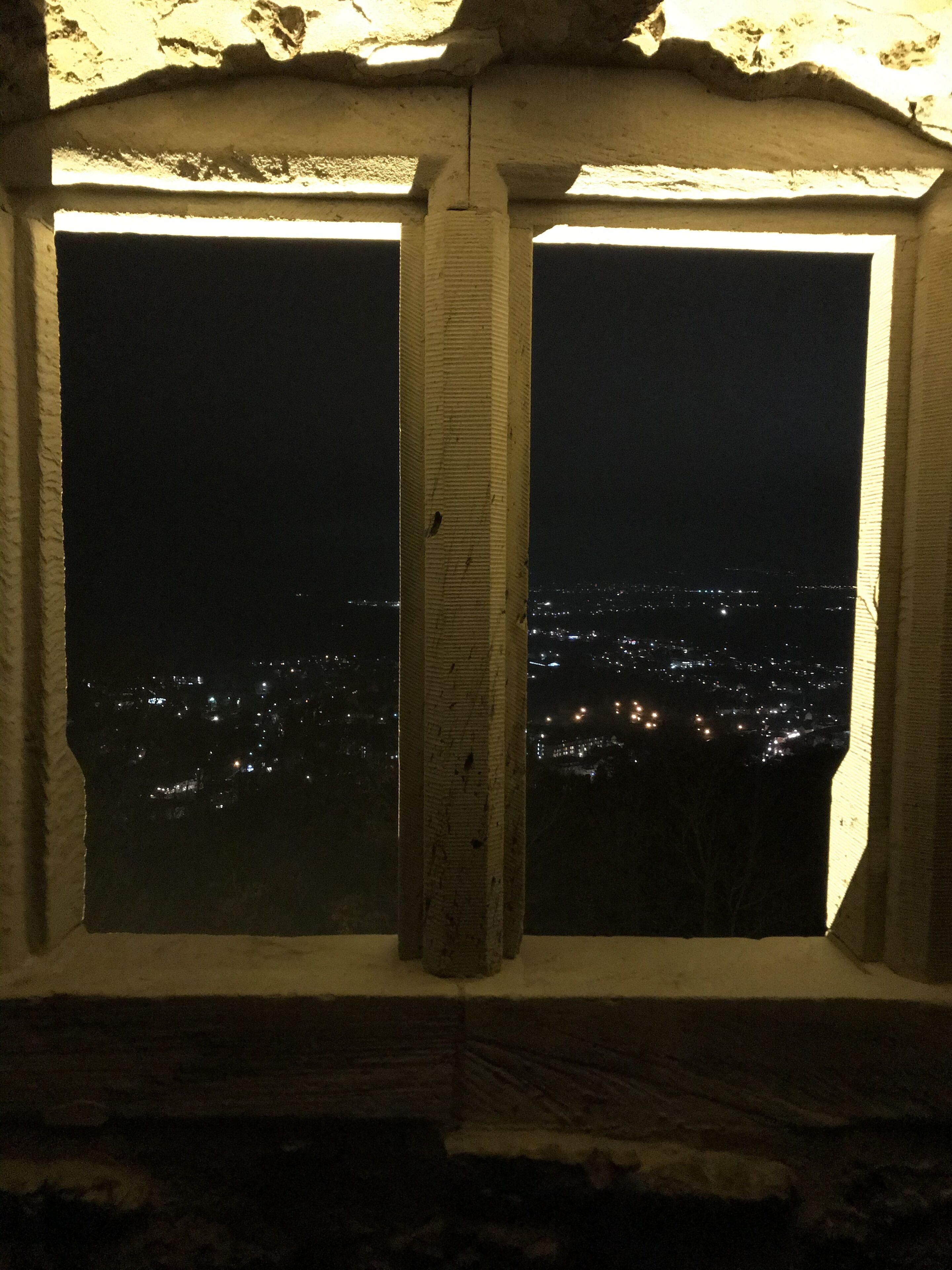 A window with a view of a cityscape at night.