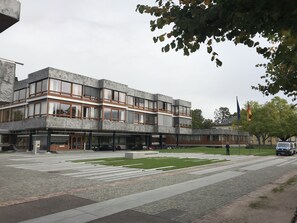 A modern building with a flat roof, large windows, and a paved area with a crosswalk. - Hotel Kull von Schmidsfelden (Bad Herrenalb)