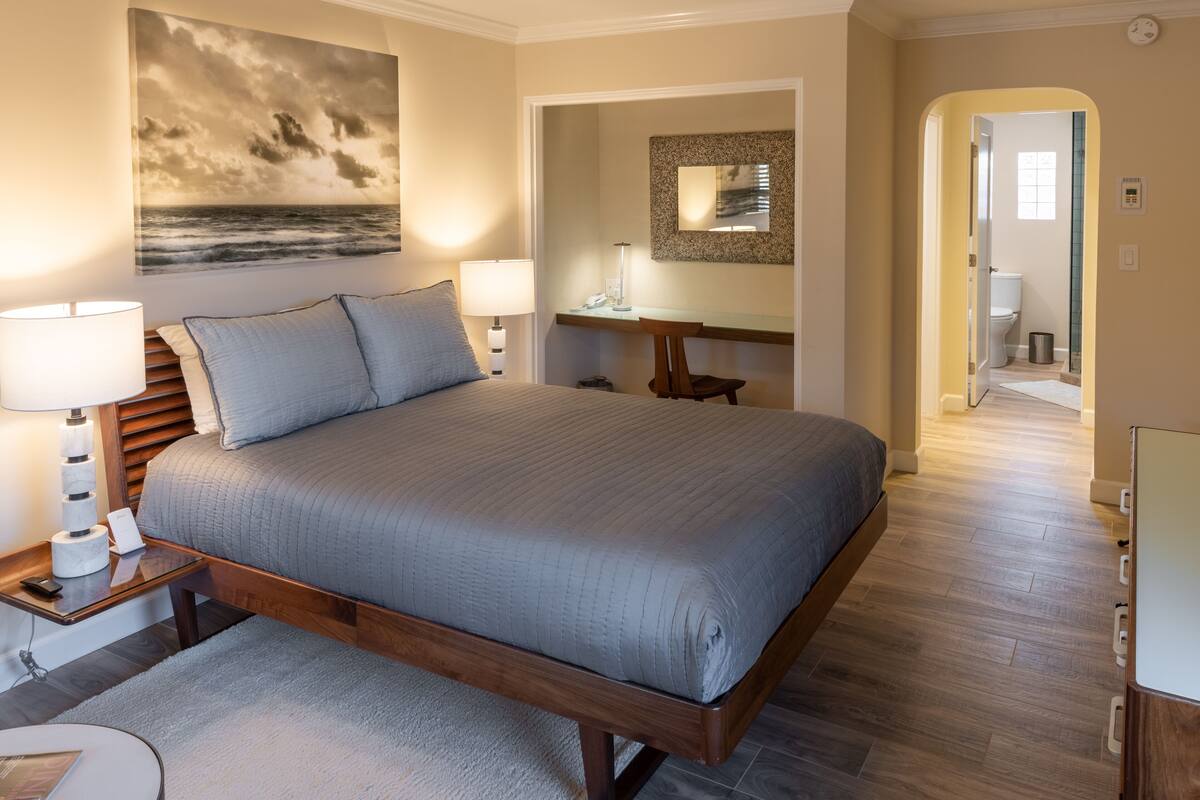 Ein Schlafzimmer mit einem großen Bett, Nachttischen, einem Schreibtisch und einem Stuhl.
