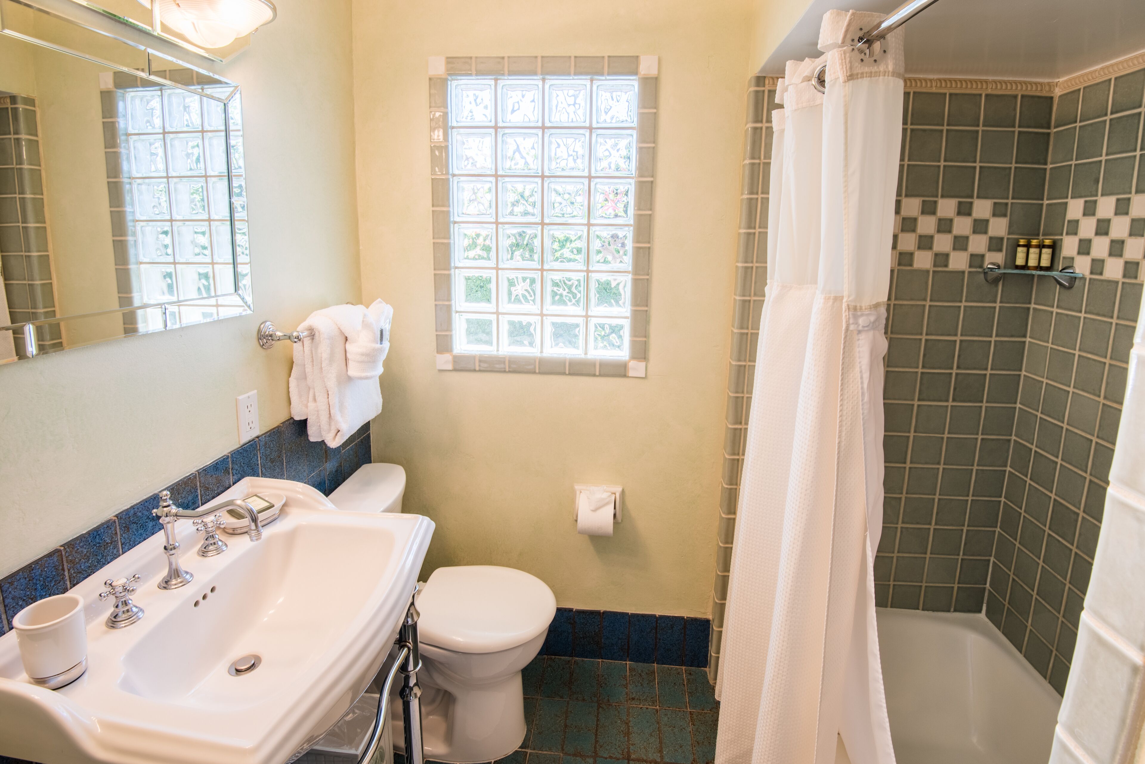 A bathroom with a white sink, toilet, and shower curtain.