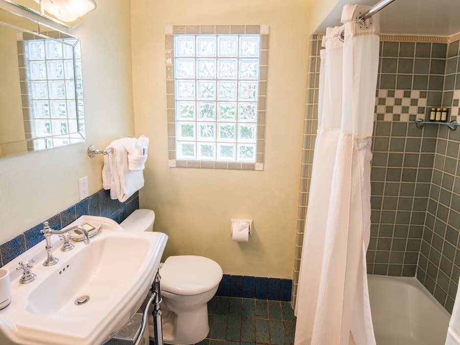 A bathroom with a white sink, toilet, and shower curtain.