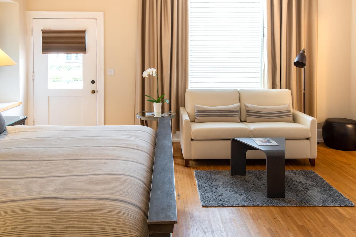 Ein Schlafzimmer mit Bett, einer Couch, einem Couchtisch und einer Lampe.