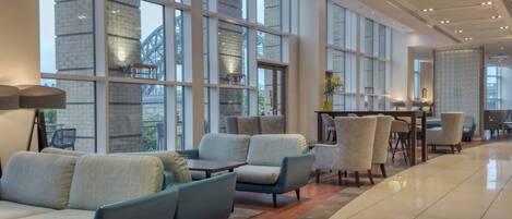 A spacious lobby with large windows, comfortable seating, and a clean, modern design.