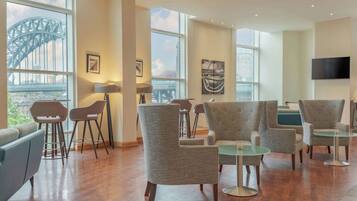 A spacious room with large windows, modern furniture, and artwork.