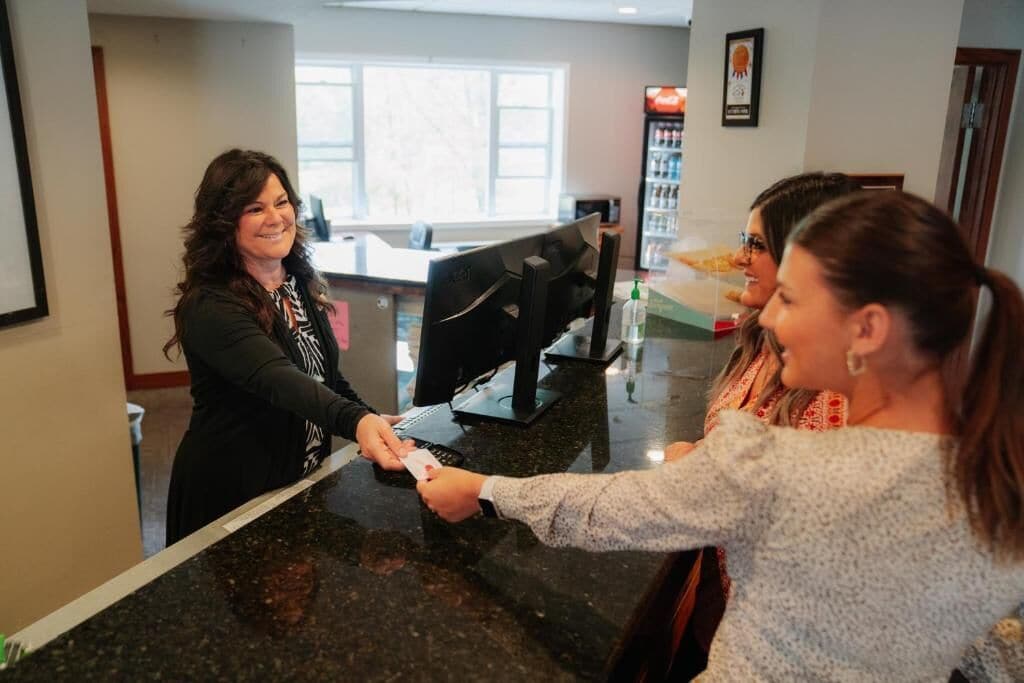 A reception area with a counter, a computer, and a window in the background.