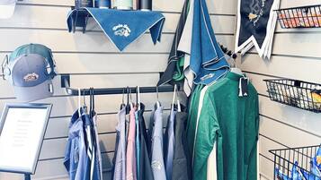 A clothing rack with various garments, a display of toiletries, and a framed sign with text.
