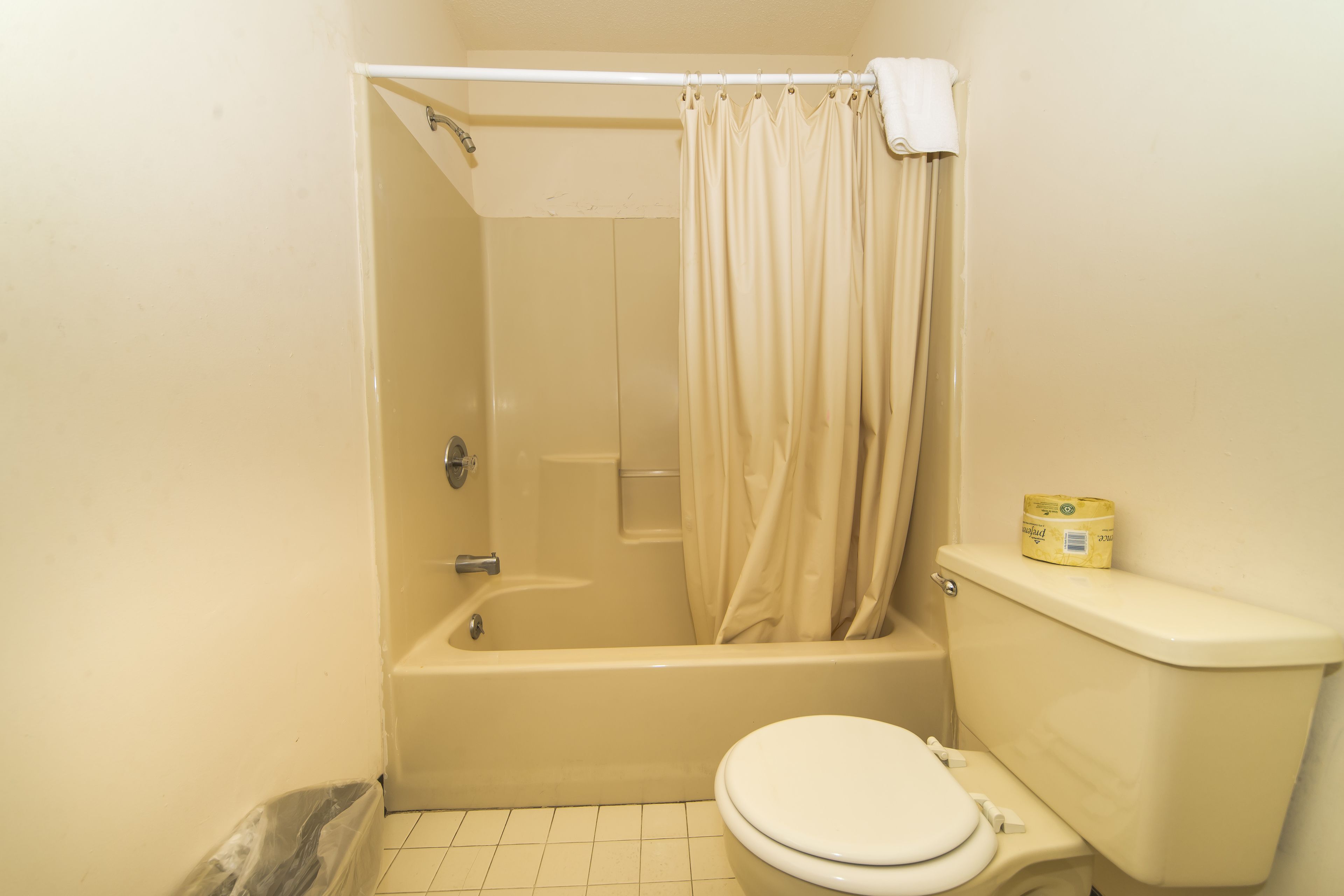A small bathroom with a bathtub, toilet, and a shower curtain.