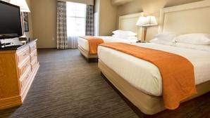 A hotel room with two beds, a TV, a dresser, and a window with curtains. - Drury Inn & Suites San Antonio North Stone Oak (San Antonio)