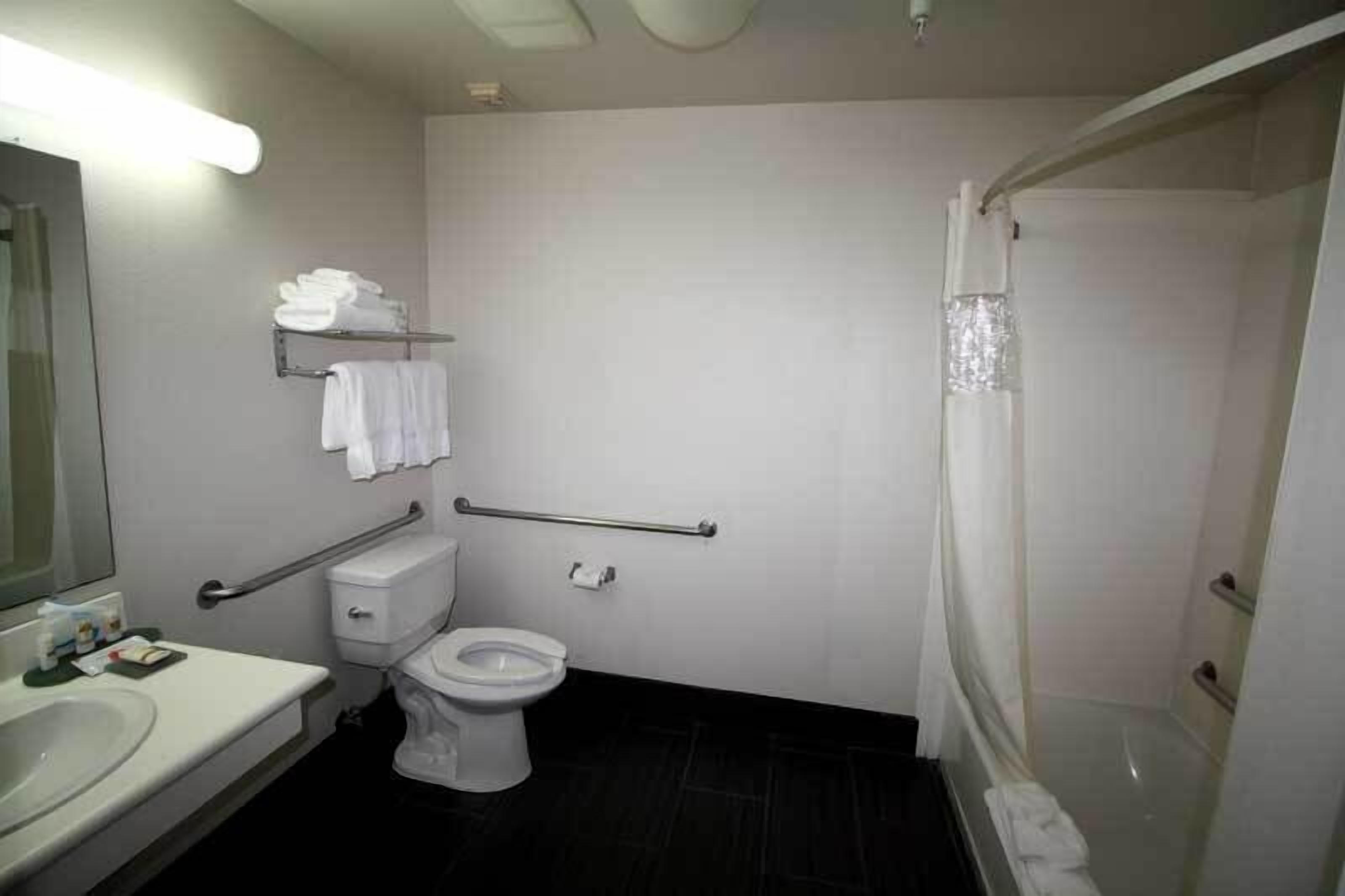 Une salle de bain comprenant des toilettes, un lavabo et un espace douche.