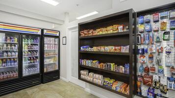 Un magasin doté de présentoirs réfrigérés pour les boissons, d’étagères remplies de collations et de boissons, et d’un assortiment de produits de toilette.