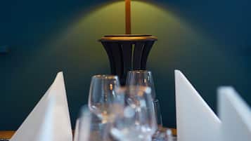 A table set with multiple wine glasses and a lamp with a dark shade.