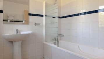 A bathroom with a white sink, a glass shower enclosure, and a bathtub.
