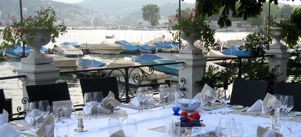Mesa lista para comer con vista a barcos y al agua.