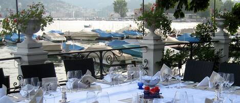 Mesa lista para comer con vista a barcos y al agua.