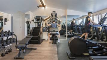 Una palestra con tapis roulant, macchinari per pesi e pesi liberi.