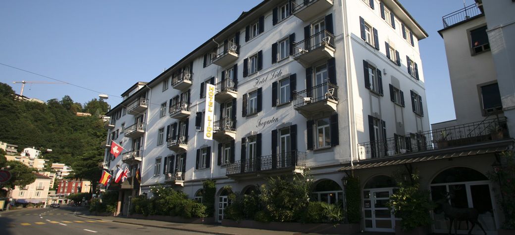 Un hotel de varios pisos con balcones, un letrero que dice "Hotel Liba" y una bandera.