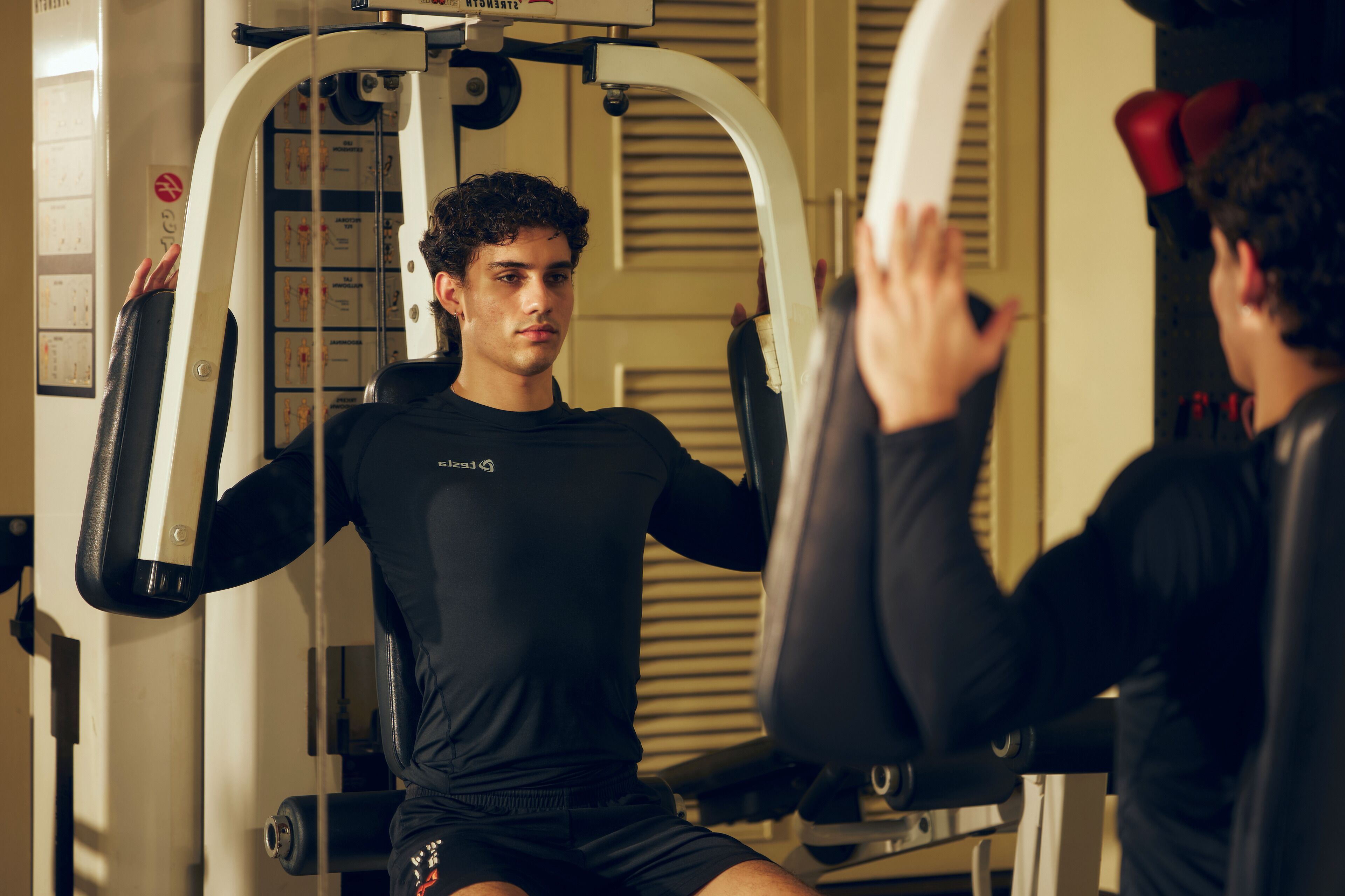 A gym with exercise equipment and a mirror.