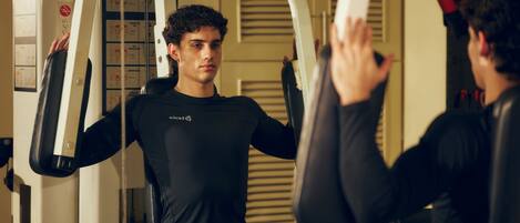 A gym with exercise equipment and a mirror.