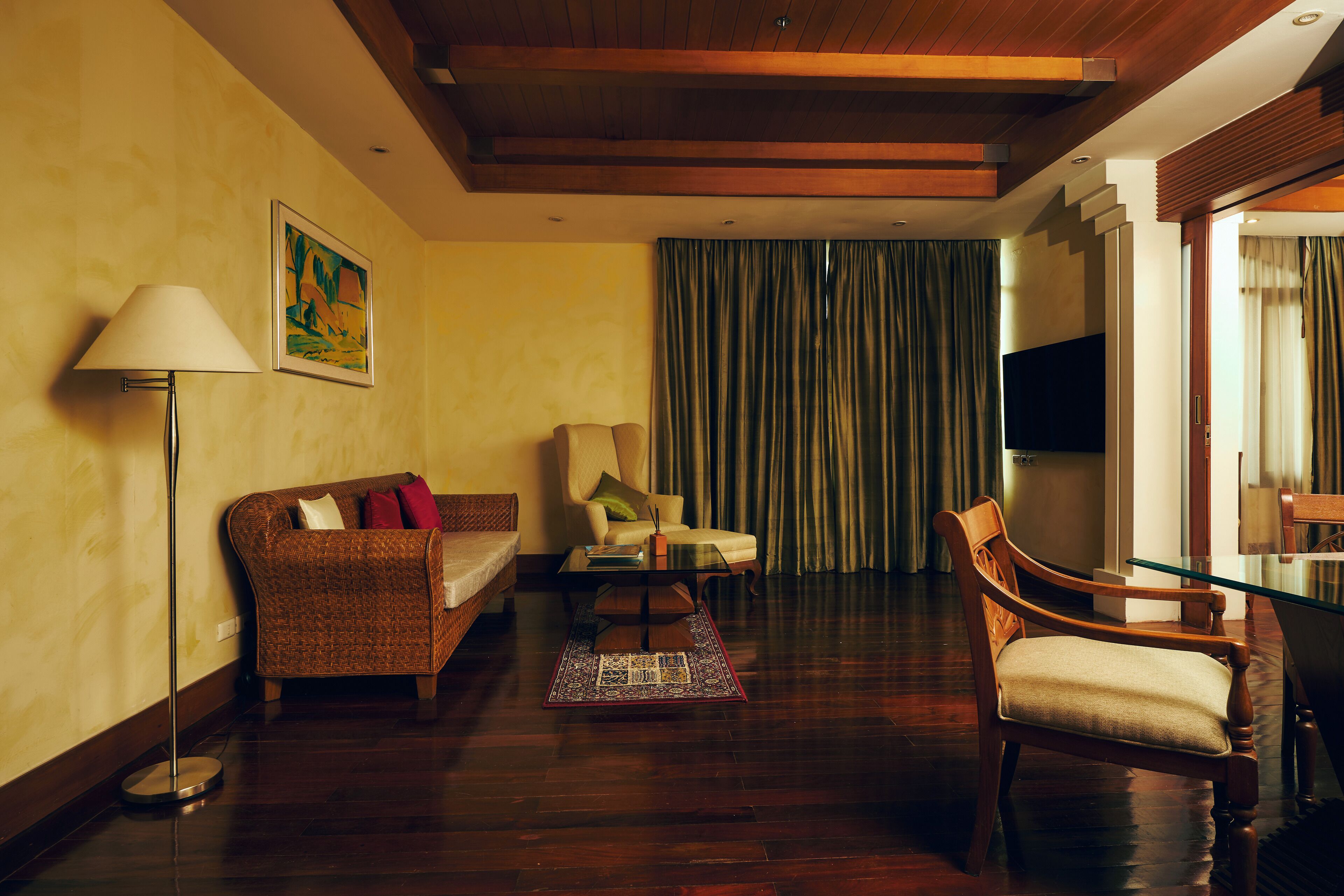 Una sala de estar con un sofá, un sillón y una mesa de centro de vidrio.