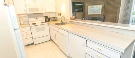 A modern kitchen with white cabinets, a dishwasher, and a microwave.