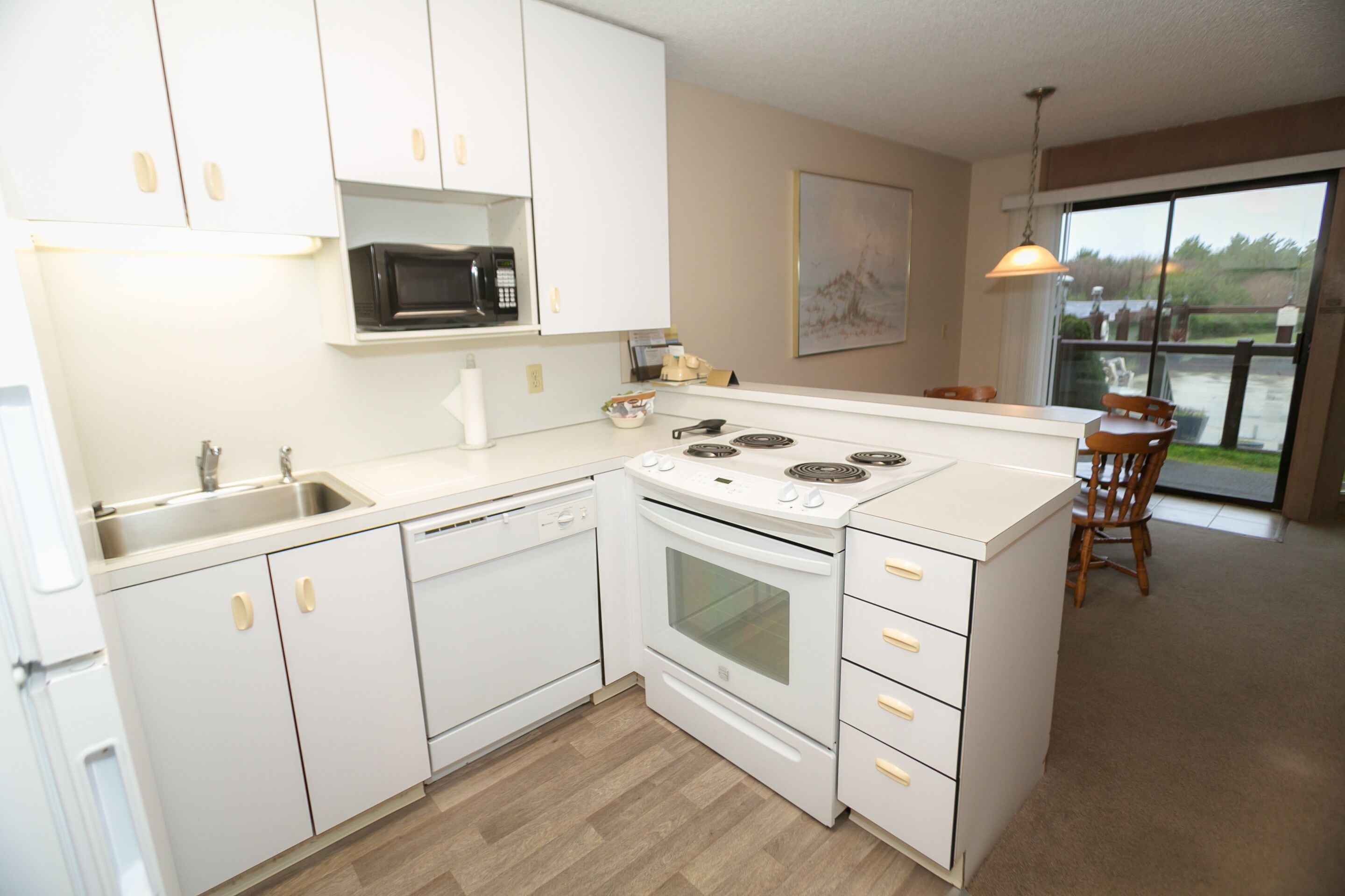 A modern kitchen with white cabinets, a built-in microwave, a stove, and a dishwasher.