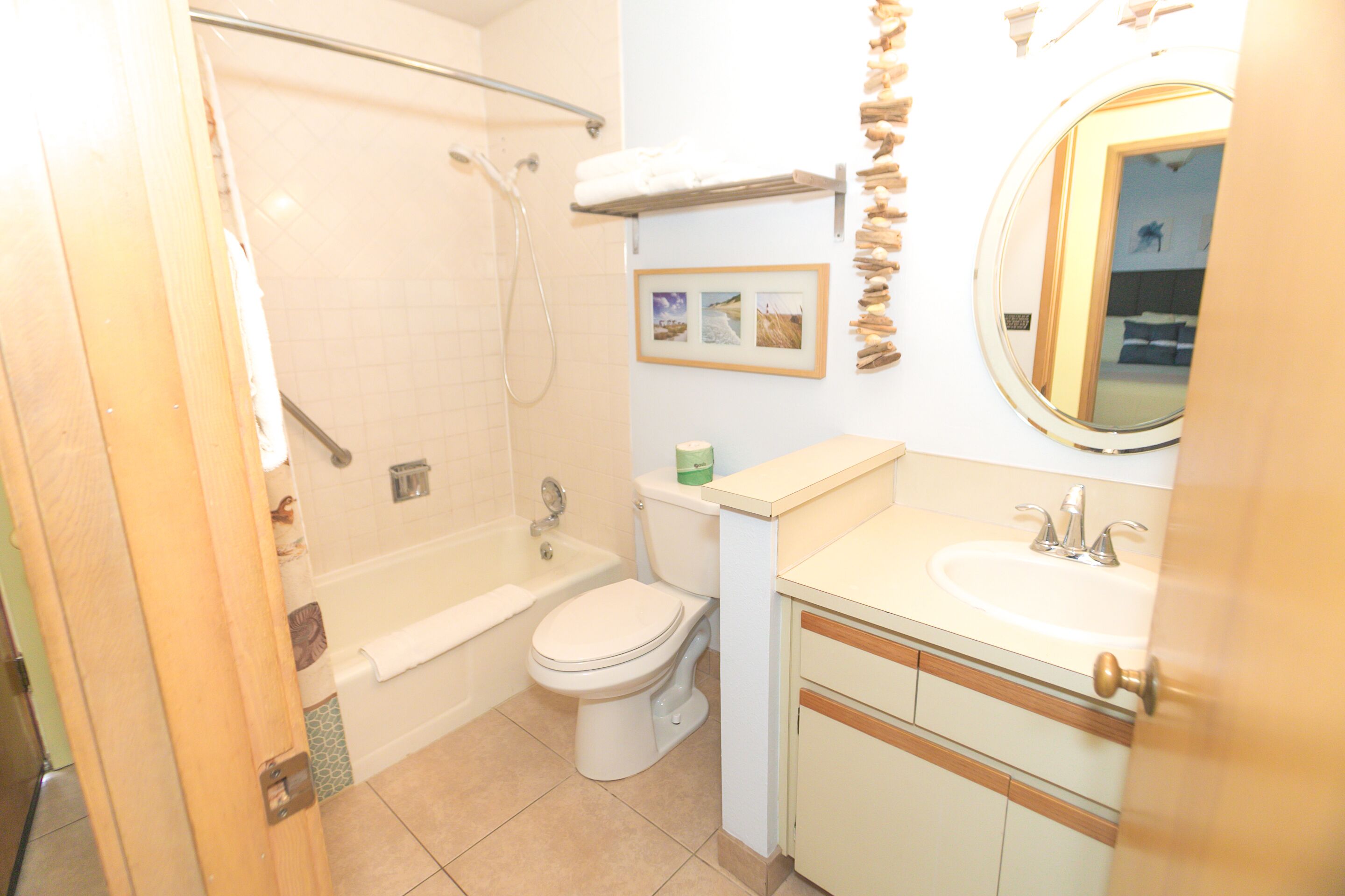 A bathroom with a bathtub, toilet, sink, and a mirror.