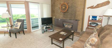A living room with a fireplace, a television, a sofa, and a coffee table.