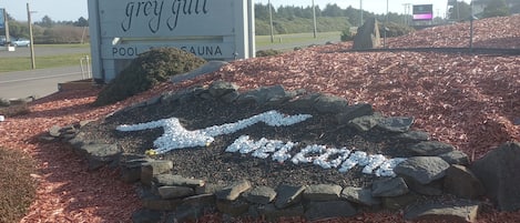 Placa de 'The Grey Gull Pool & Sauna', com um caminho de pedra que leva até ele.