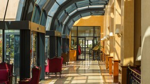 A spacious atrium with a glass ceiling, red seating, and a central walkway. - Hotel Concorde Les Berges du Lac (Tunis)