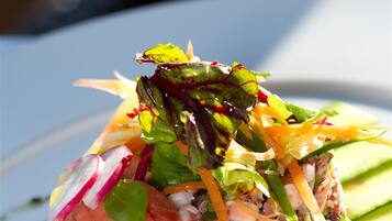A salad with various vegetables and a dressing on a plate.
