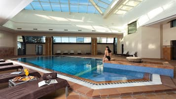 Una piscina techada, sillones reclinables de piscina