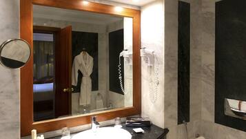 Une salle de bain moderne avec un grand miroir, un lavabo, des toilettes et un sèche-cheveux.