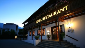 A hotel restaurant with a wooden facade, large windows, and a sign that reads "HOTEL RESTAURANT". - Hotel Schatzmann (Triesen)